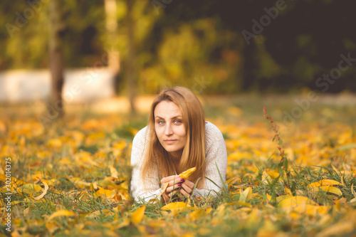 Young woman playing with autumn leaves 
