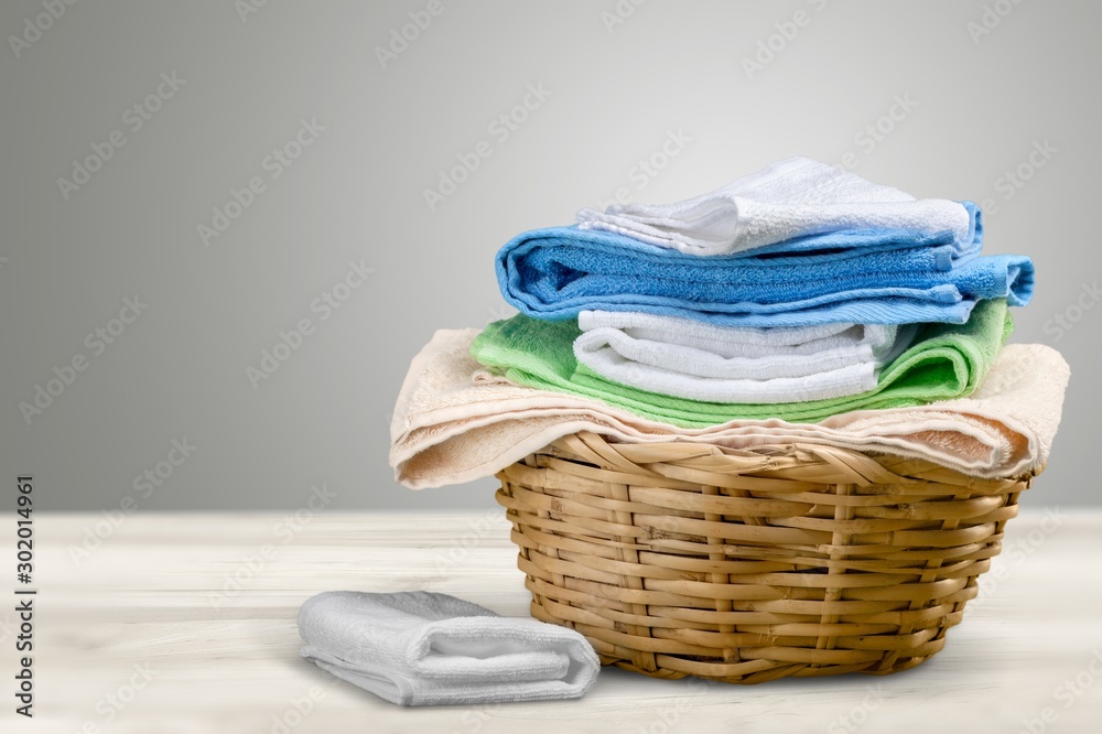 Laundry Basket with colorful towels on background Laundry Basket with colorful towels on background