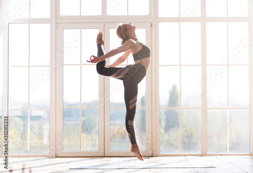 Beautiful young flexible woman exercising at studio