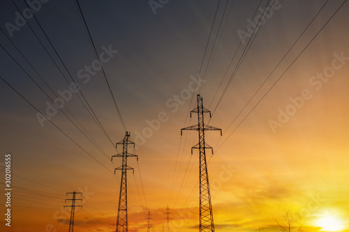 Power lines at sunset, sun rays. High voltage tower against the sky. Energetics