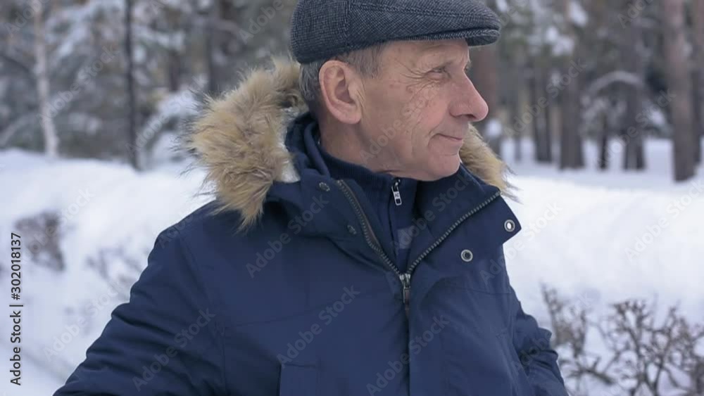senior man walking in the winter Park, nature walks for health senior man walking in the winter Park, nature walks for health