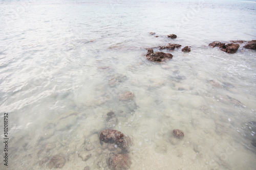 Beautiful seascape of the rocky beach and sea wave on seaside with cloudy in sky at Samila beach in Thailand photo