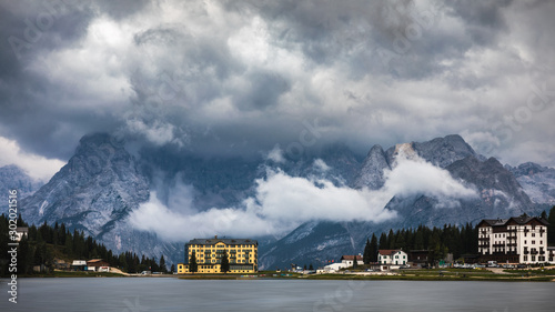 Misurina Lake in the Dolomites mountains in Italy near Auronzo di Cadore on a cloudy day, Sorapiss mountain in the background. South Tyrol, Dolomites, Italy. photo