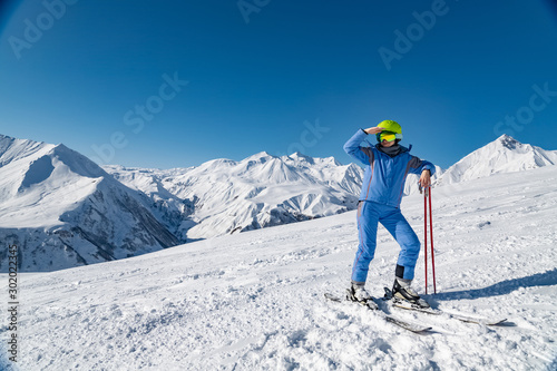 Female skier standing on beautiful mountain landscape background. Winter, ski, snow, vacation, sport, leisure, lifestyle concept
