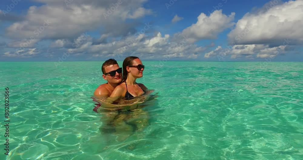 Couple enjoying leisure time on their while hugging inside the crystal clear waters of the Maldives in Couple enjoying leisure time on their while hugging inside the crystal clear waters of the Maldives in