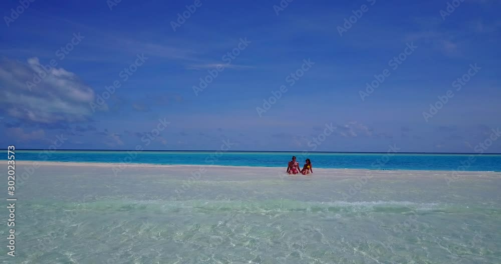 Couple having some leisure time on top of a sandbar in the middle of nowhere, Hawaii Couple having some leisure time on top of a sandbar in the middle of nowhere, Hawaii
