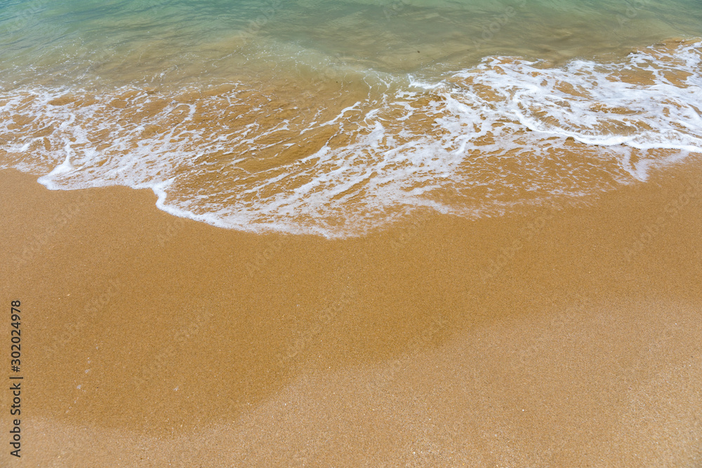 Blue ocean wave on sandy beach. Soft wave of blue ocean on sandy beach. Background. Top view of Beautiful beach with tranquil wave, sea and ocean background, summer vacation concept.