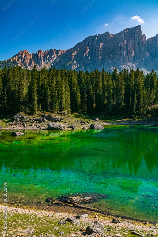 Beautiful alpine view with reflections and the Latemar mountains at the famous Karersee, South Tyrol, Italy