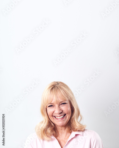 Studio Shot Of Smiling Mature Woman Against White Background At Camera