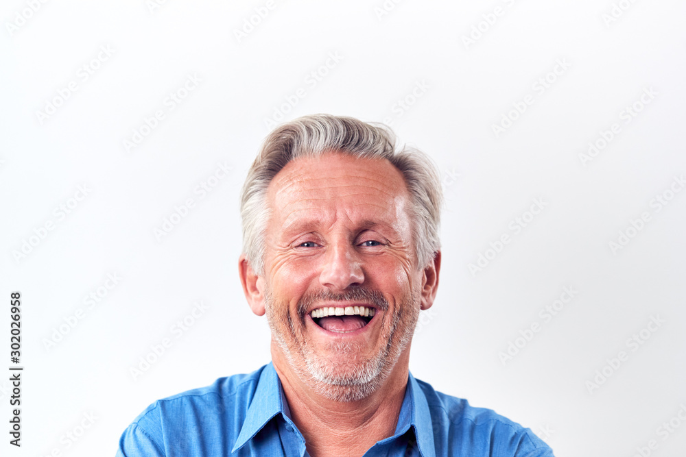 Studio Shot Of Mature Man Against White Background Laughing At Camera Studio Shot Of Mature Man Against White Background Laughing At Camera