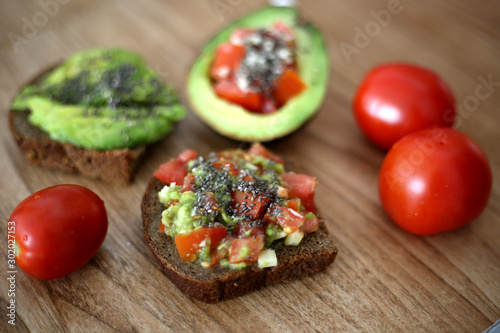 Close up avocado toast with chia seeds  fresh tomato garlic  in the restaurant. Healthy menu.