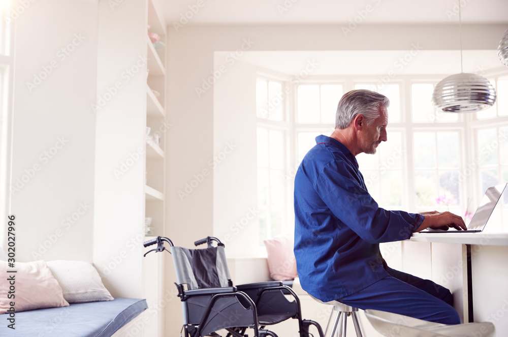 Mature Man In Wheelchair Looking Up Information About Medication Online Using Laptop Mature Man In Wheelchair Looking Up Information About Medication Online Using Laptop