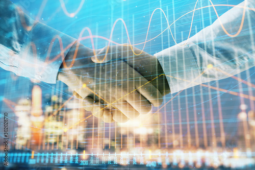 Wallpaper Mural Double exposure of financial chart on cityscape background with two businessmen handshake. Concept of financial analysis and investment opportunities Torontodigital.ca