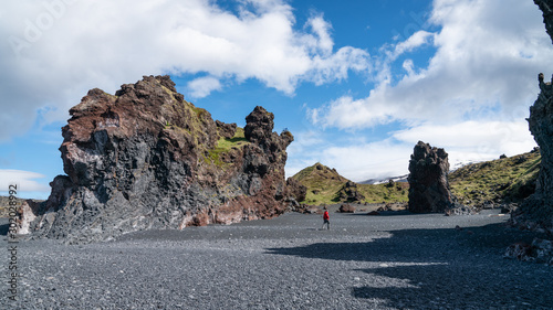Unidentified man walking in volcanic lava rocks at Djupalonssandur beach in Snaefellsnes peninsula in Western Iceland photo