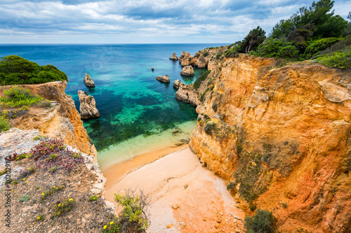 View of stunning beach with golden color rocks in Alvor town , Algarve, Portugal. View of cliff rocks on Alvor beach, Algarve region, Portugal.