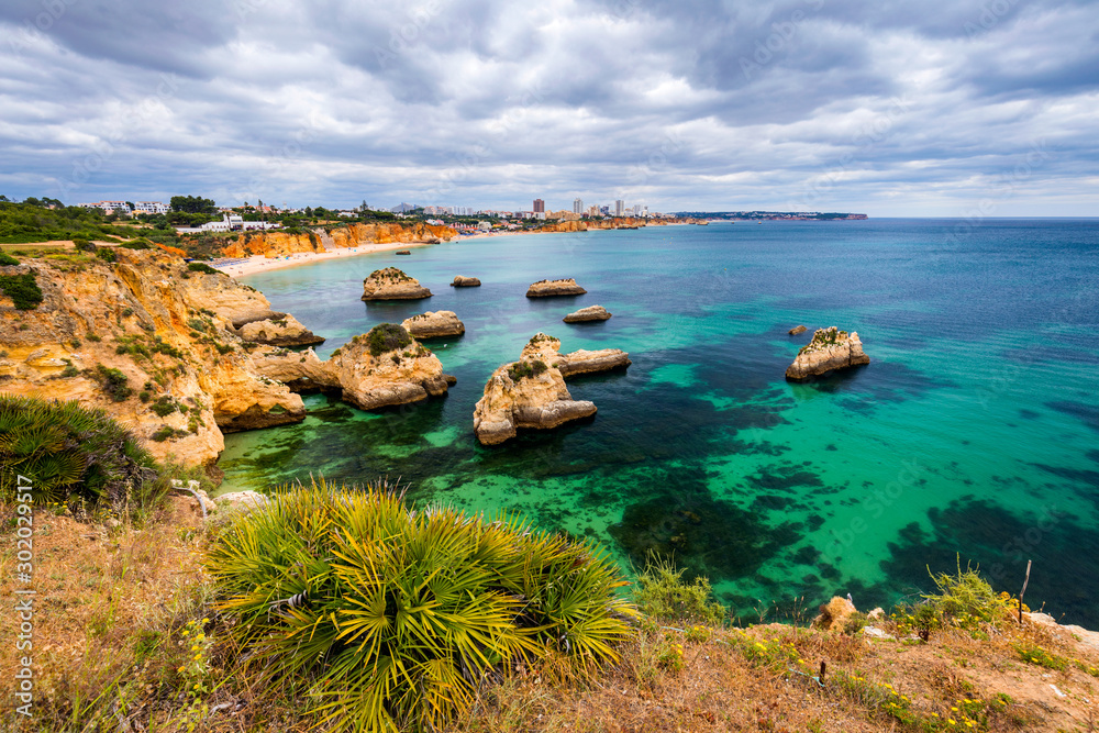 View of stunning beach with golden color rocks in Alvor town , Algarve, Portugal. View of cliff rocks on Alvor beach, Algarve region, Portugal.