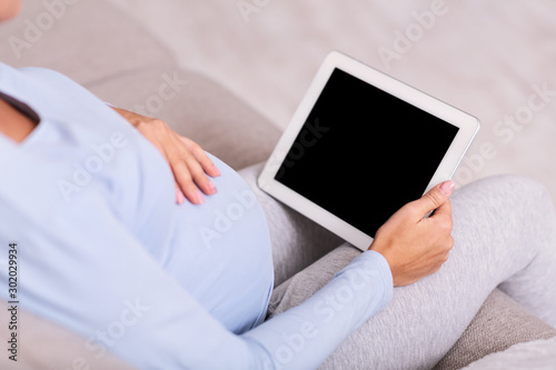 Unrecognizable Expectant Lady Using Tablet Sitting On Couch Indoor, Mockup