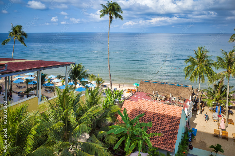 Phu Quoc island, Vietnam - March 30, 2019: hotel with a pool on the coastline of the Indian Ocean, high palm trees, sea horizon