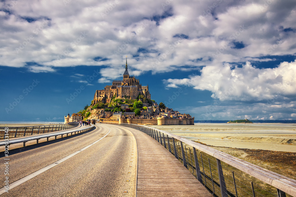 Fototapeta premium Beautiful panoramic view of famous Le Mont Saint-Michel tidal island with blue sky. Normandy, northern France