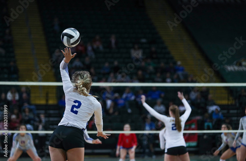 A young woman serves during a volleyball tournament