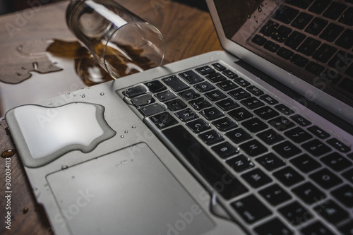 Obraz na plátně Glass of spilled water on laptop