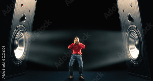 Photos The man cover his ears from loud noise wafting out from big sound speakers with funny faces