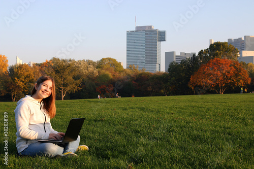 Photography teenage girl with laptop in park sunny autumn day