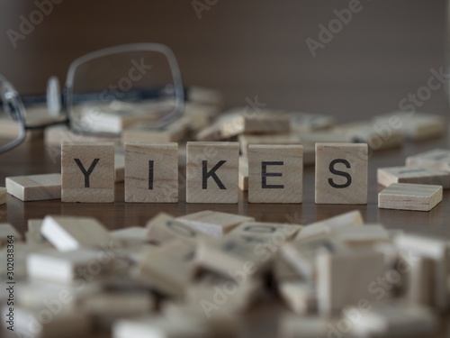 The concept of yikes represented by wooden letter tiles photo