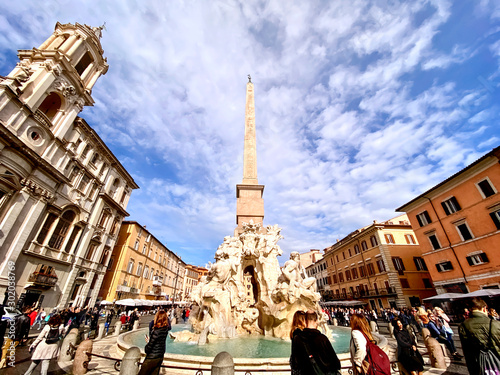 crowd of people enjoying a sunny autumn day walking near the famous fountain of the four rivers in the center of Piazza Navona in Rome Fototapet