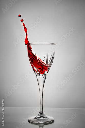 Splashes of dry red wine frozen in flight on a gray background