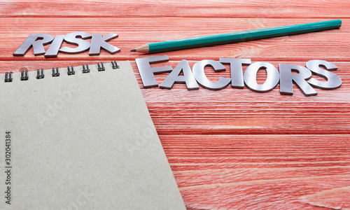 iron letters risk factors with notebook and green pencil