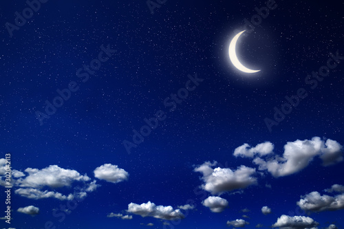 Moon in cloudy night with alot of stars and dark blue sky background