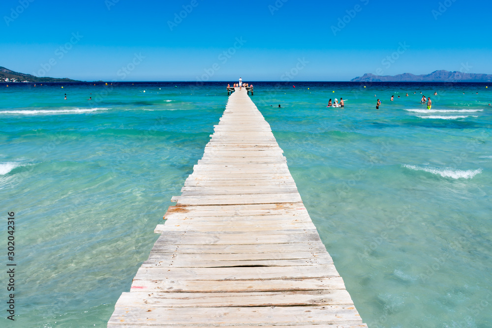 wooden pier on the shore of the Mediterranean sea in Alcudia in Mallorca