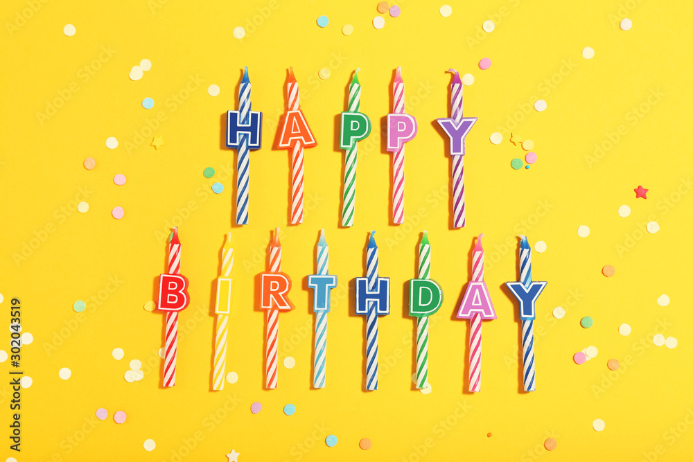 Candles with text Happy Birthday on yellow background. Minimalism concept Candles with text Happy Birthday on yellow background. Minimalism concept