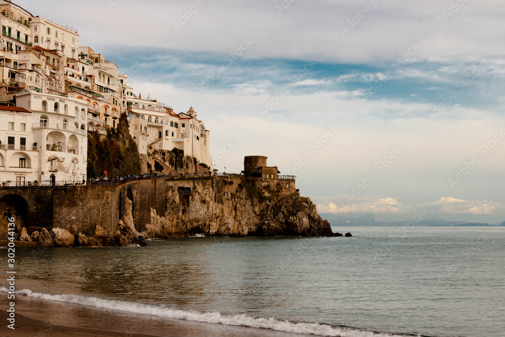 AMALFI, ITALY NOVEMBER 7 2019: Amalfi resort beautiful city view on houses, fortress and sea beach from the pier