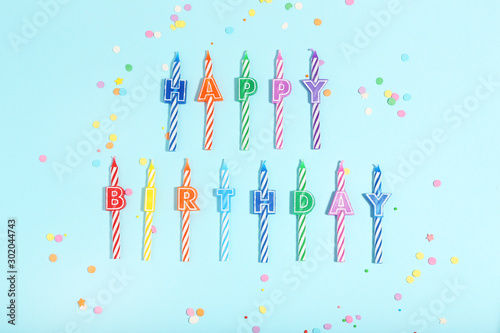 Candles with text Happy Birthday on blue background. Minimalism concept