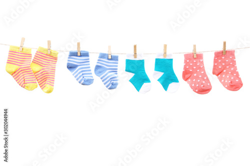 Baby socks hanging on white background