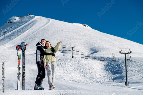 Young happy couple in snowy mountains. Winter sport vacation