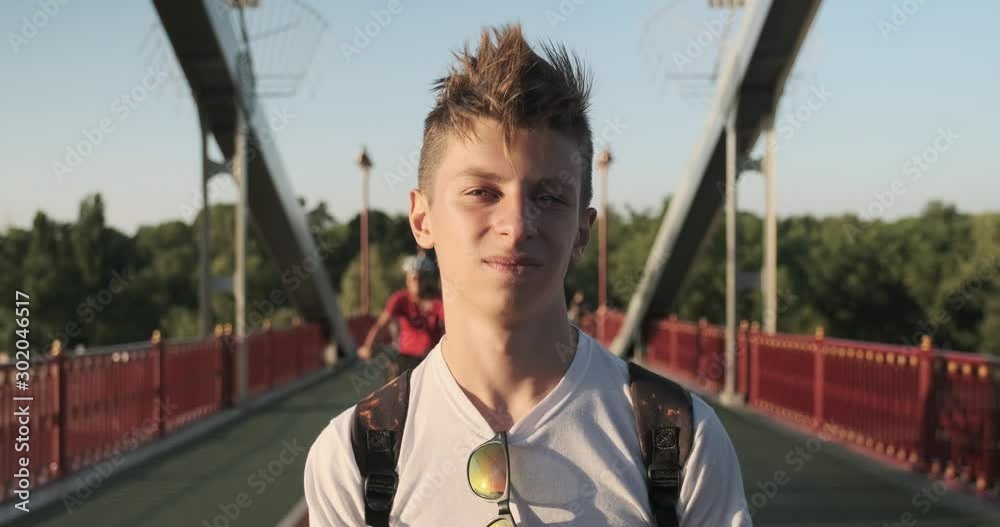 Teen boy 15 years old with fashionable hairstyle looking at the camera