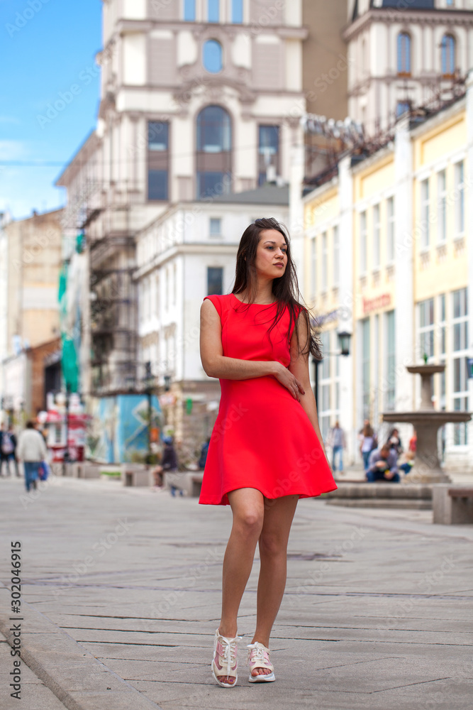 Young beautiful woman in red dress on the summer street Young beautiful woman in red dress on the summer street