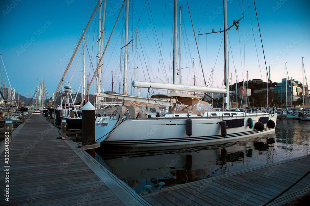 Fototapeta premium wooden surface pier and boats docked at dawn in the marina of Cartajena