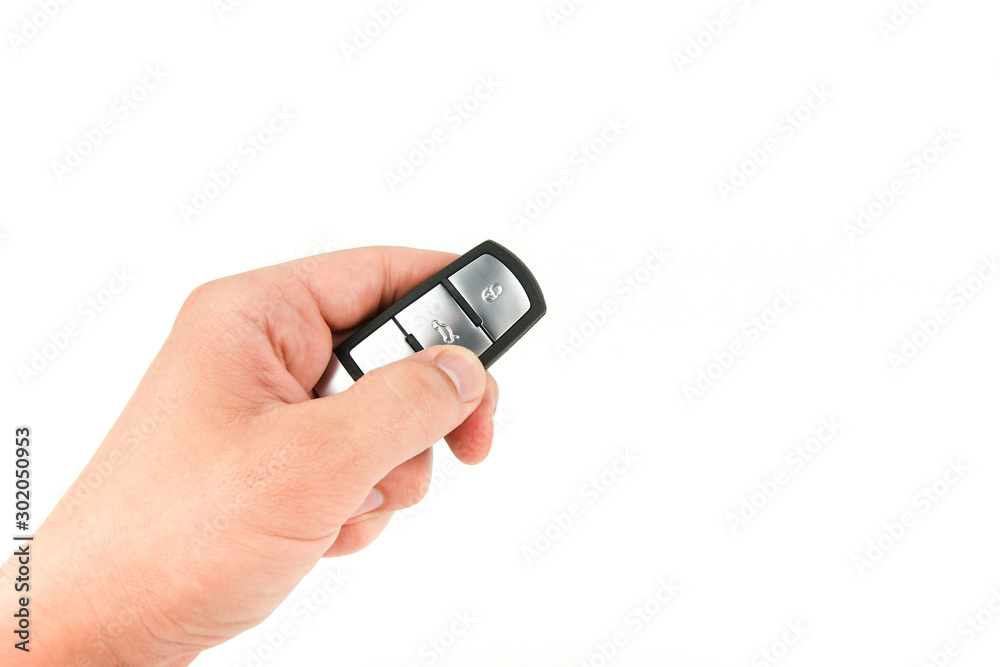 open the trunk of a car with button on the keychain. man's hand holds car key on white background with copy space open the trunk of a car with button on the keychain. man's hand holds car key on white background with copy space