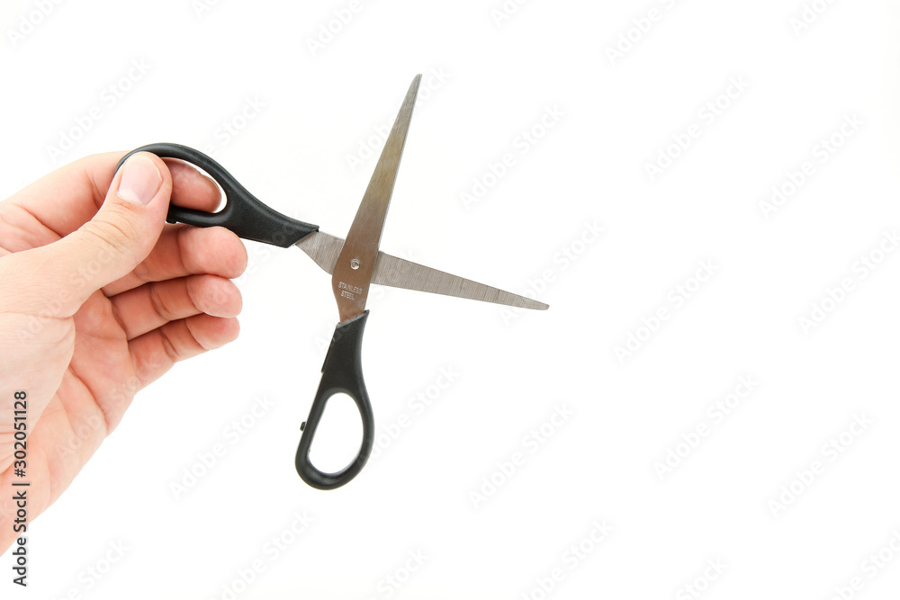 man's hand is holding a scissors on a white background with copy space. man's hand is holding a scissors on a white background with copy space.