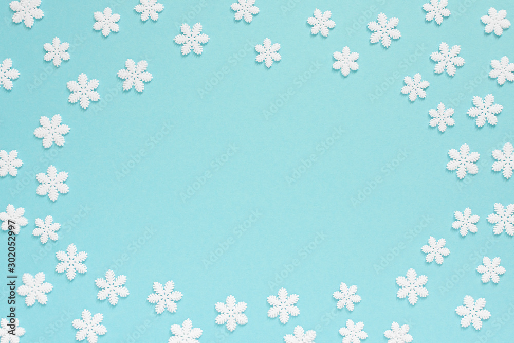 Holiday pastel background, white snowflakes on a gentle blue background ,flat lay, top view
