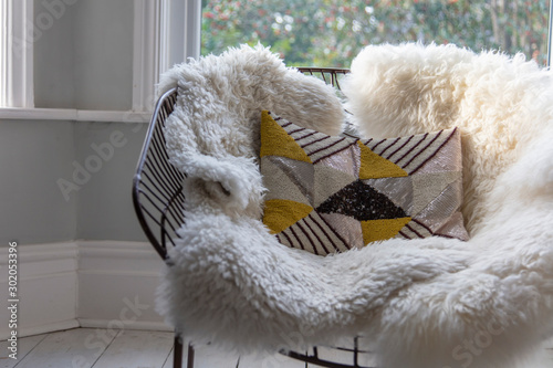 Modern armchair covered in soft furnishings in a bright room photo