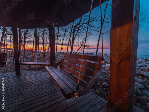 Obraz na plátně Wooden swing on the shore of Lake Ladoga