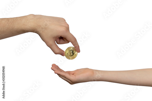 Cryptocurrency Inheritance Concept. The hand of an adult transfers gold bitcoin to the child’s hand. Inheritance, translation.