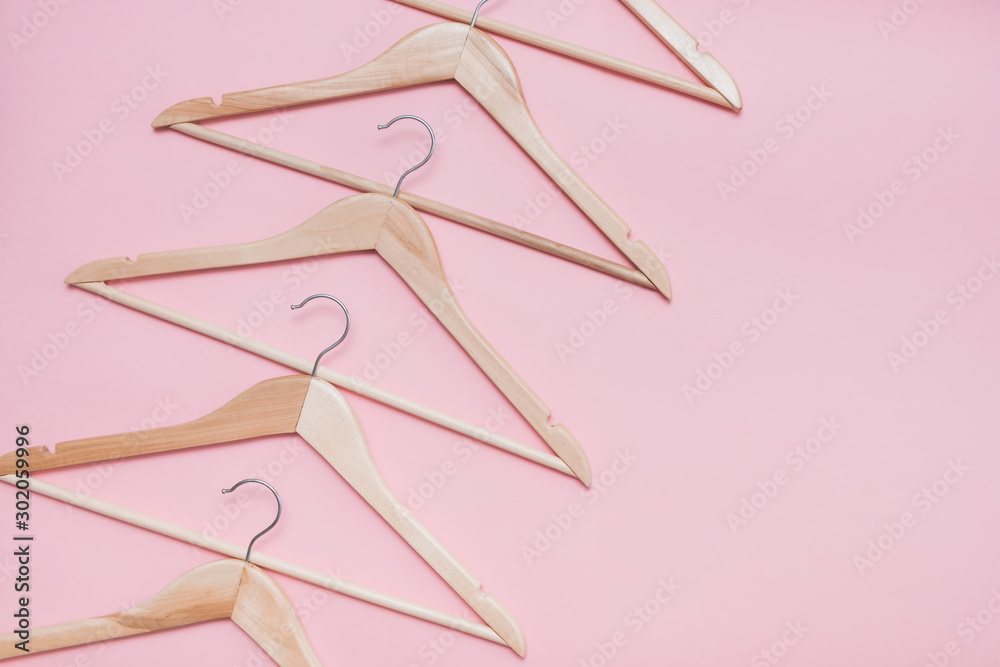 wooden empty clothes hangers on a pink background. concept: pop modern sale wooden empty clothes hangers on a pink background. concept: pop modern sale