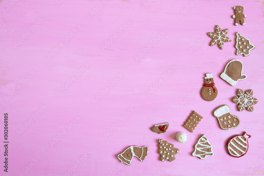 Christmas homemade gingerbread cookies on pink wooden background