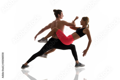 Improving flexibility through pilates training. Couple of athletes training together isolated on white. Athletic training. Physical training activity and sport. Fitness